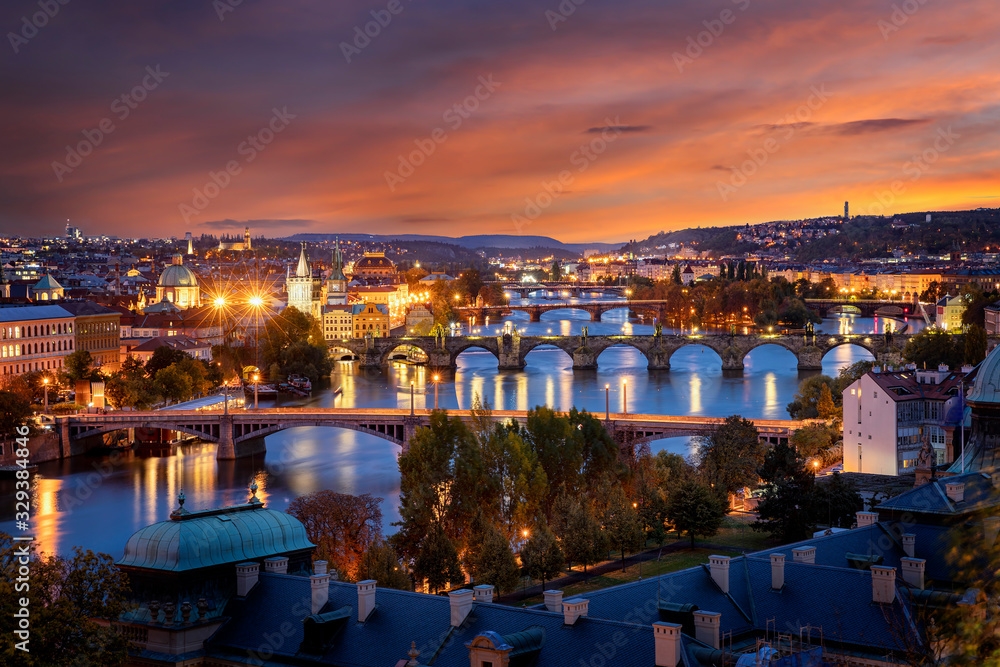 Panoramblick auf die Stadtlichter von Prag mit den zahlreichen Brücken über die Moldau, der Altstadt und romantischem Himmel bei Sonnenuntergang. Tschechien