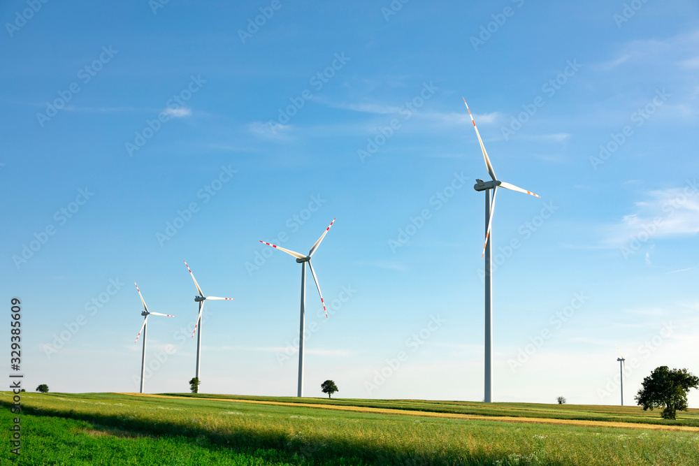 wind turbines in green field, countryside area with blue sky wind turbines in green field, countryside area with blue sky