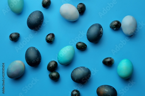 Easter chicken and quail eggs on a pastel blue background. The view from the top. Easter concept.