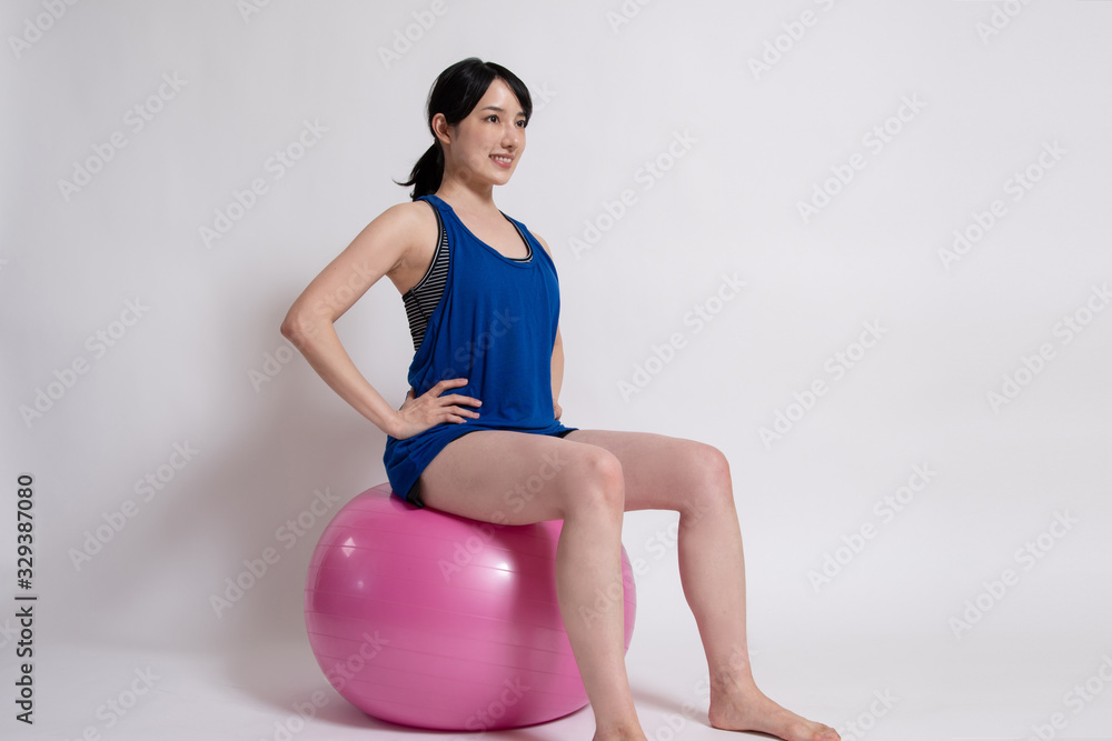 バランスボールでエクササイズをする女性 バランスボールでエクササイズをする女性