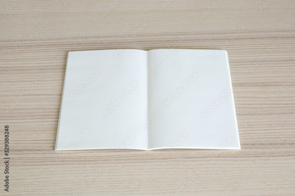 Mock up blank open paper book on wood table background