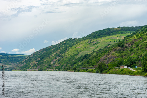 Germany, Rhine Romantic Cruise, a body of water with a mountain in the background © SkandaRamana