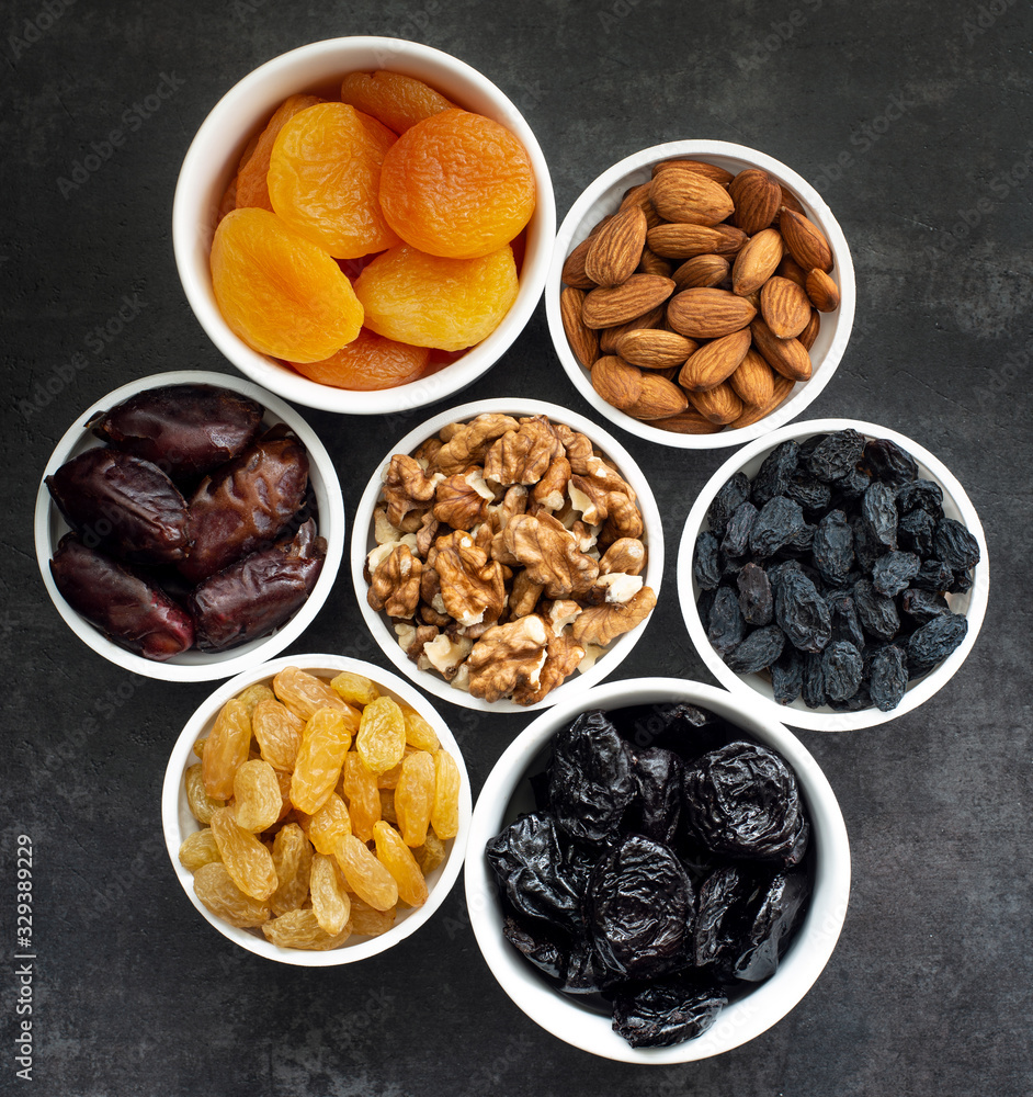 Dried fruits in white bowls on a dark background to maintain cardiovascular health top view Dried fruits in white bowls on a dark background to maintain cardiovascular health top view