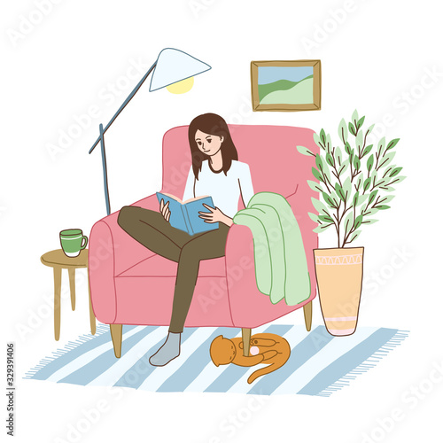 Young woman is relaxing in the armchair with book.