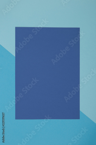 Blue background, colored paper geometrically divides into zones, frame, copy, space.