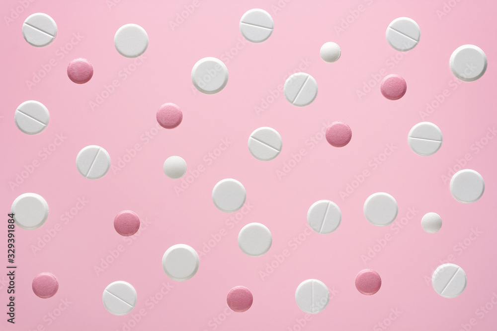 white and pink round medical pills on a color background white and pink round medical pills on a color background