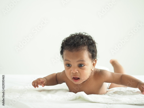  Afaricn male newborn baby lying in bed and wriggle  in the morning.Happy,excited and enjoy emotion. photo