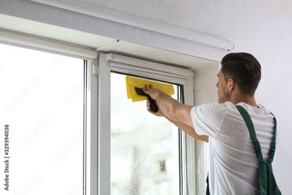 Professional worker tinting window with foil indoors. Space for text Professional worker tinting window with foil indoors. Space for text
