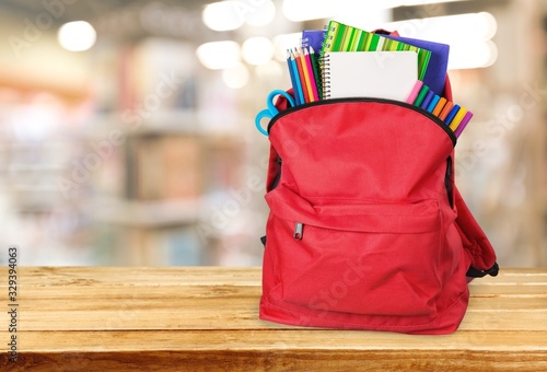 Modern schoolbag with various supplies for education
