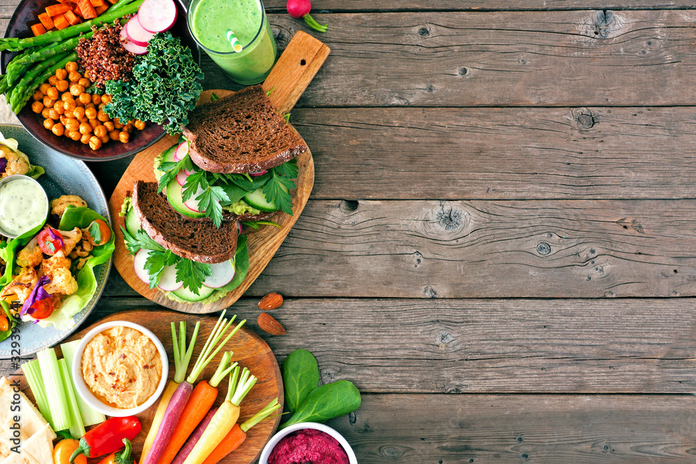 Healthy lunch food side border. Table scene with nutritious hearty bowl, sandwiches, lettuce wraps and vegetables. Top view over a rustic wood background. Copy space. Healthy lunch food side border. Table scene with nutritious hearty bowl, sandwiches, lettuce wraps and vegetables. Top view over a rustic wood background. Copy space.