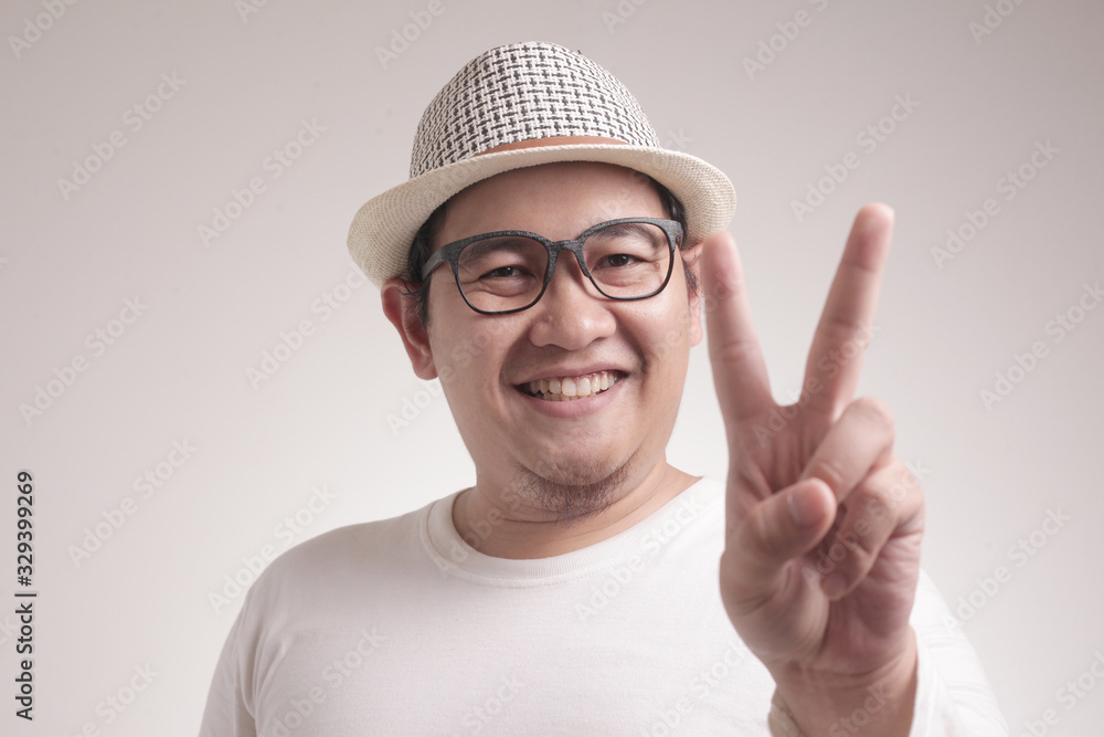 Naklejka premium Young Man Shows Number Two or Peace Sign Gesture