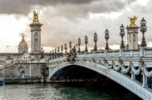 Scenic Alexander III bridge with ornate light posts and Dome des Invalides cathedral in a distance, Paris, France