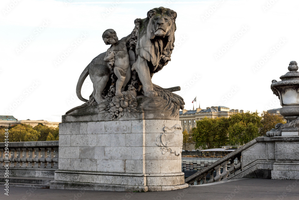 A stone sculpture of a nymph and lion at the entry to the Alexander III bridge and access to Seine river, Paris, France