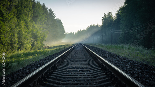 Obraz na płótnie train rails in the sun and  electric poles