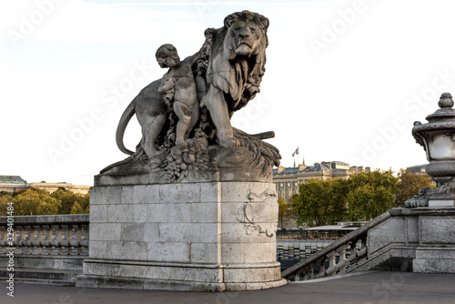 A stone sculpture of a nymph and lion at the entry to the Alexander III bridge and access to Seine river, Paris, France © anastasstyles