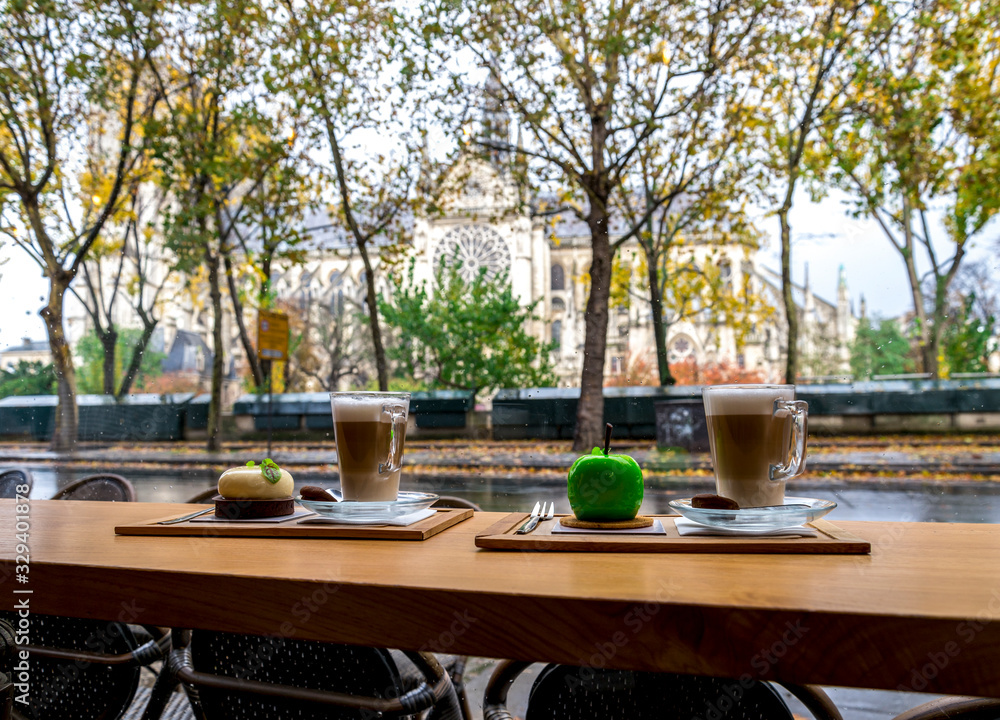 Cups of coffee and delicious deserts in a café opposite to Notre-Dame de Paris cathedral, France