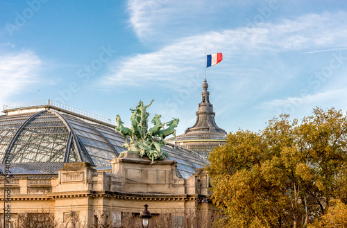 One of two quadrigas sculptures and a French flag raised at Grand Palais museum building, Paris, France. Sculptor: Georges Recipon (1860-1920) photo