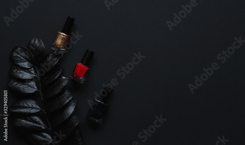 Red, golden and black Nail polish  and luxury leaf  on a black background wit...