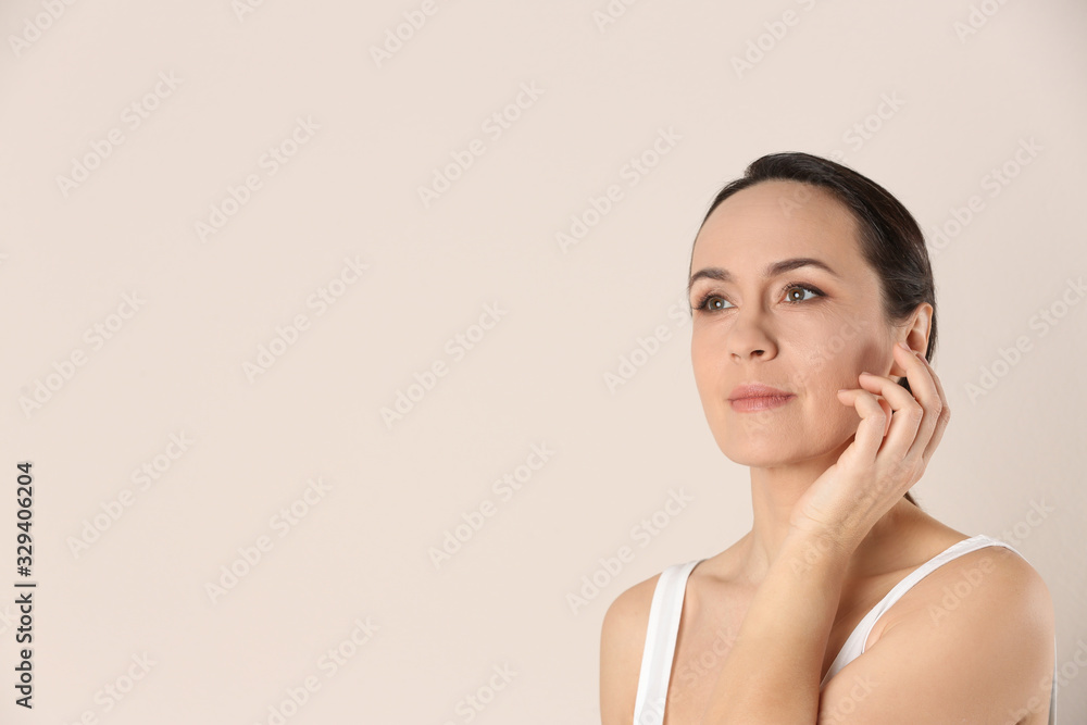 Portrait of beautiful mature woman on beige background. Space for text Portrait of beautiful mature woman on beige background. Space for text