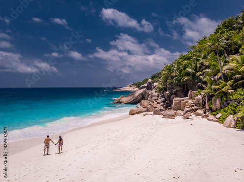 Seychelles tropical islands, Praslins Island Seychelles with couple walking on the tropical beach with palm trees photo