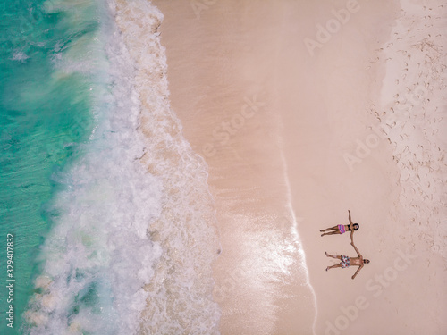 Seychelles tropical islands, Praslins Island Seychelles with couple walking on the tropical beach with palm trees photo