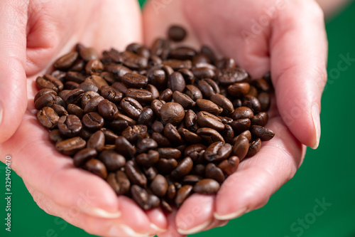 Closeup of coffee beans in the hands of a Lady.