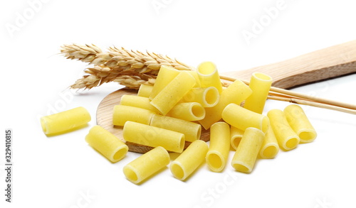 Uncooked smooth short tubes shape pasta also known as tubetti lisci in wooden spoon isolated on white background photo