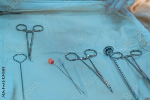 closeup, the hands of a nurses hand, an assistant surgeon takes a surgical instrument from a sterile table. In a sterile operating room.