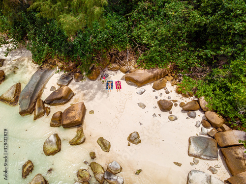 Seychelles tropical islands, Praslins Island Seychelles with couple walking on the tropical beach with palm trees photo