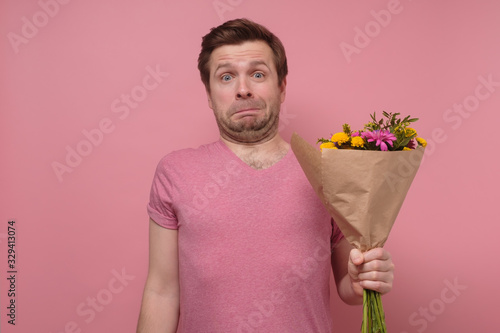 Obraz na płótnie man asking for forgiveness feeling sorry standing with flower bouquet
