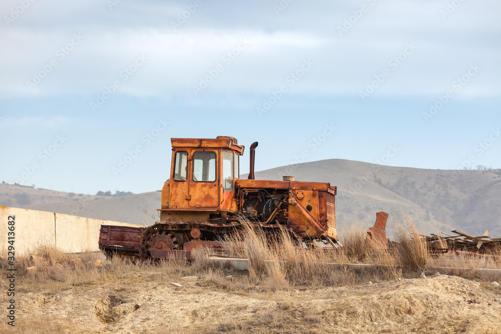 Old abandoned tractor on the street against. Old abandoned tractor on the street against.
