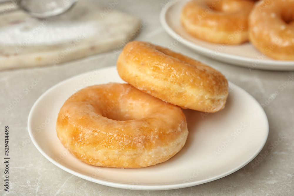 Sweet delicious glazed donuts on light table