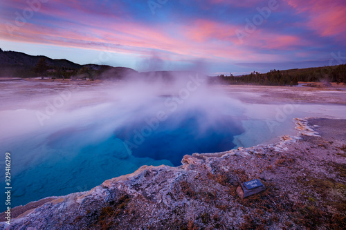 Sapphire Pool in Biscuit basin with blue steamy water and beautiful colorful sunset. Yellowstone  Wyoming  USA
