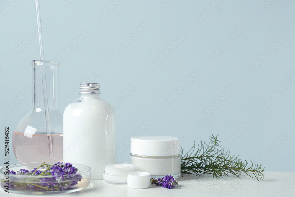 Herbal cosmetic products, laboratory glassware and ingredients on white table, space for text