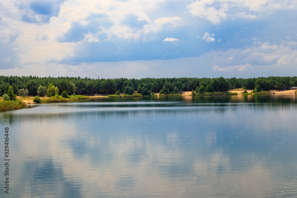 Obraz premium View of a beautiful lake in a pine forest at summer