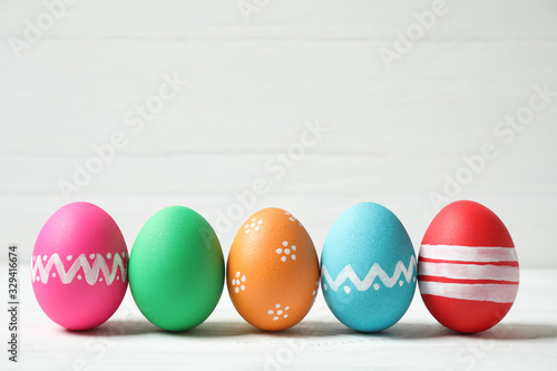 Colorful Easter eggs on white wooden background. Space for text