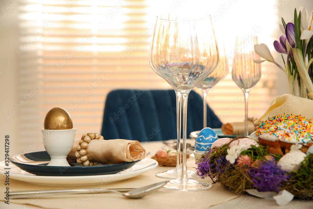 Festive Easter table setting with decorated eggs in kitchen Festive Easter table setting with decorated eggs in kitchen