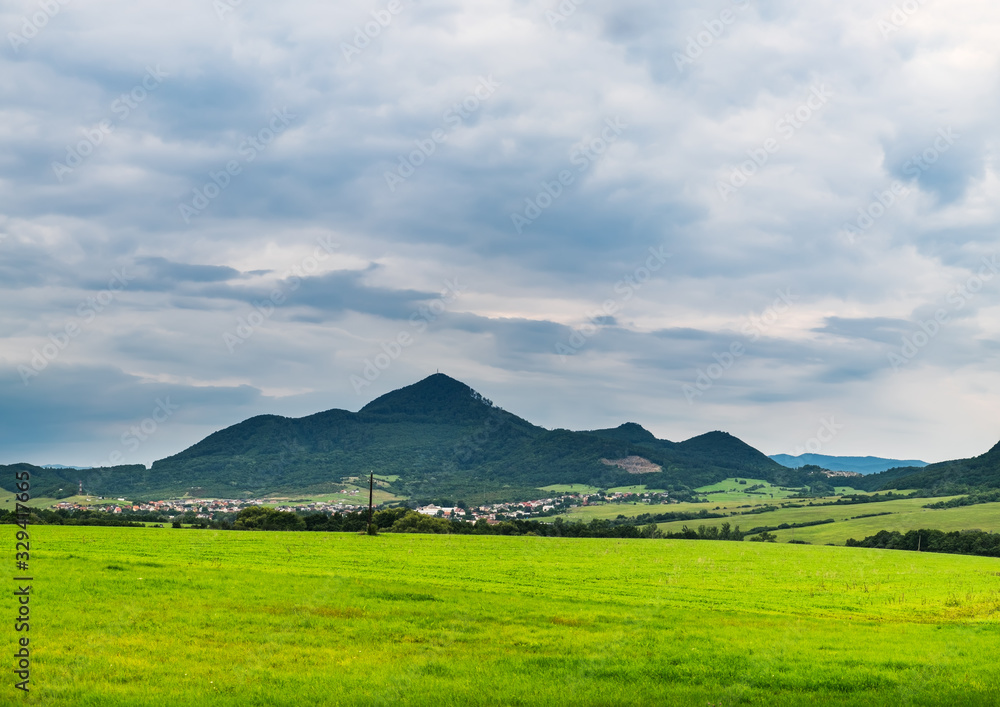 Scenic green mountain landscape in Slovakia. Beautiful valley scenery with forest and agriculture field or meadow in summer time