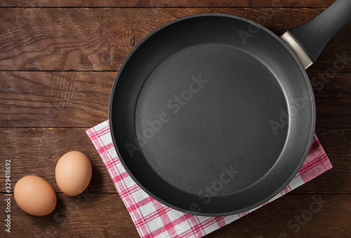 frying pan two eggs on wooden