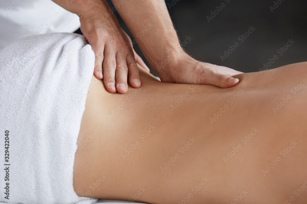 Young beautiful woman enjoying back and shouders massage in spa.Professional massage therapist is treating a female patient in apartment.Relaxation,beauty,body and face treatment concept.Home massage. Young beautiful woman enjoying back and shouders massage in spa.Professional massage therapist is treating a female patient in apartment.Relaxation,beauty,body and face treatment concept.Home massage.