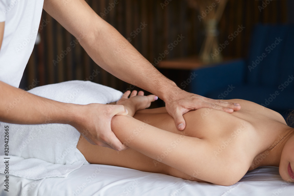 Young beautiful woman enjoying back and shouders massage in spa.Professional massage therapist is treating a female patient in apartment.Relaxation,beauty,body and face treatment concept.Home massage. Young beautiful woman enjoying back and shouders massage in spa.Professional massage therapist is treating a female patient in apartment.Relaxation,beauty,body and face treatment concept.Home massage.