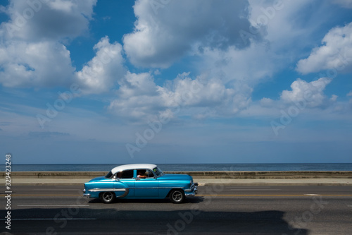 A classic blue car driving through the streets of Havana © Layna Fernandez