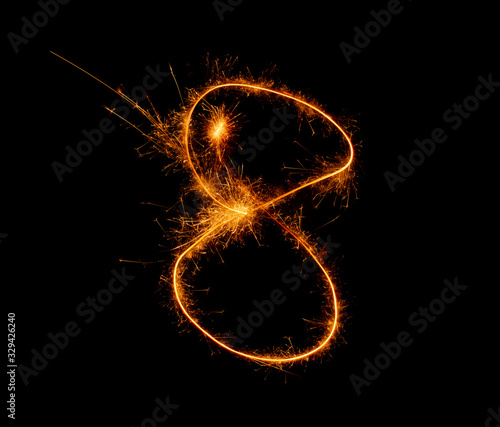 number eight written with a sparkler on a black background