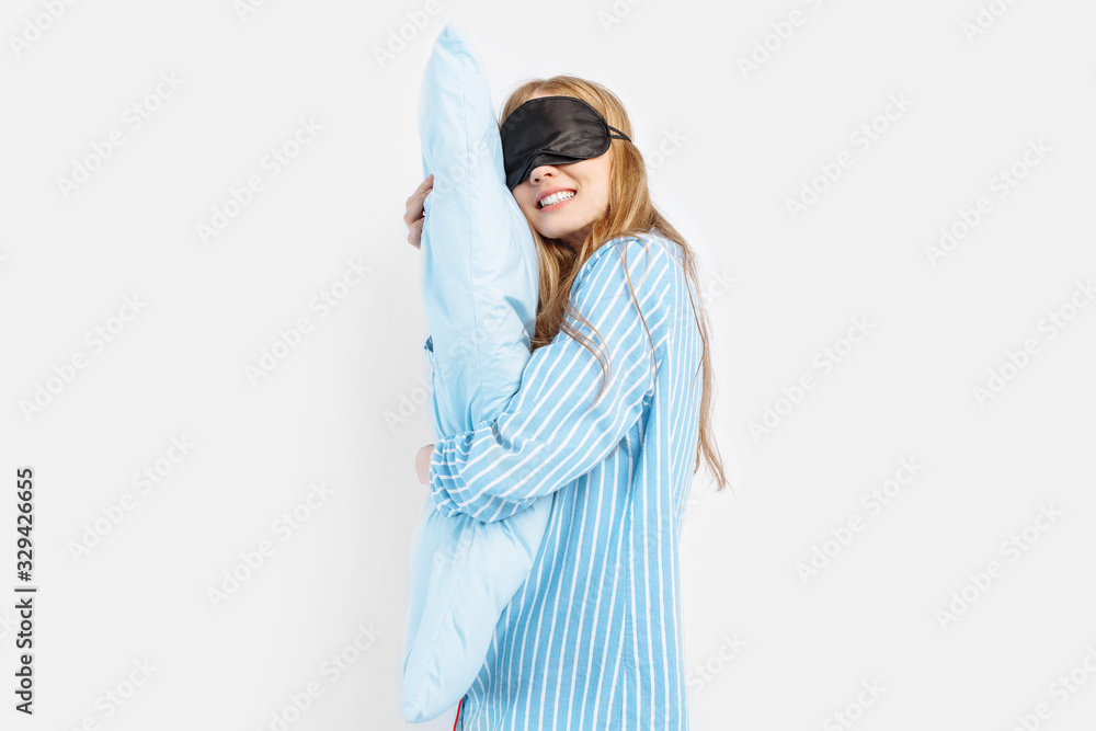Obraz premium Portrait of beautiful cute sleeping girl in pajamas hugging pillow sleeping on white background