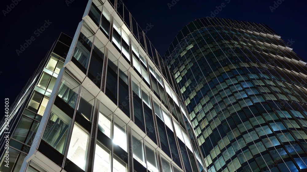 Pattern of office buildings windows illuminated at night. Lighting with Glass architecture facade design with reflection in urban city. Pattern of office buildings windows illuminated at night. Lighting with Glass architecture facade design with reflection in urban city.