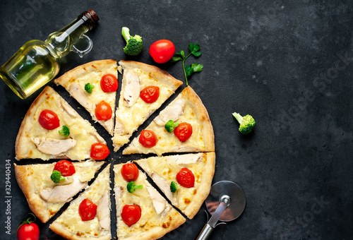 delicious pizza with pineapple, broccoli, tomatoes, mozzarella cheese, chicken fillet on a stone background with copy space for your text