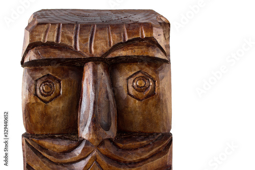 Part of isolated wooden carvings depicting a person's face. Ancient style. Object on the left side of the photo, with place for text