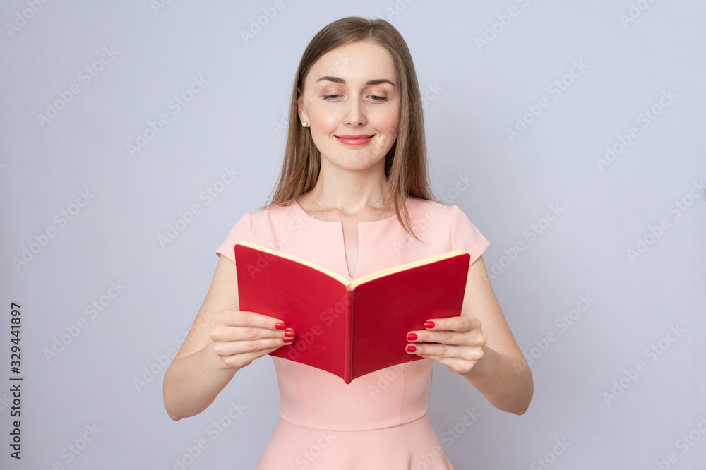 Attractive woman reads red book, portrait, copy space Attractive woman reads red book, portrait, copy space