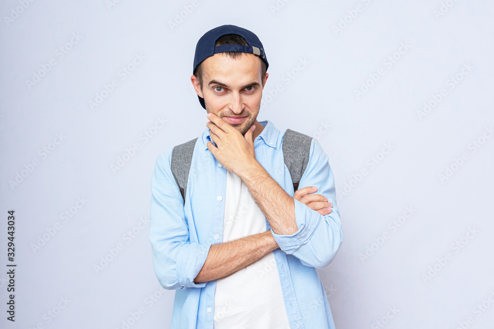 Sly guy with backpack, portrait, grey background, copy space, toned Sly guy with backpack, portrait, grey background, copy space, toned