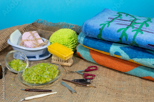 Towels, sea salt, brushes, soap and manicure devices lie on jute fabric.